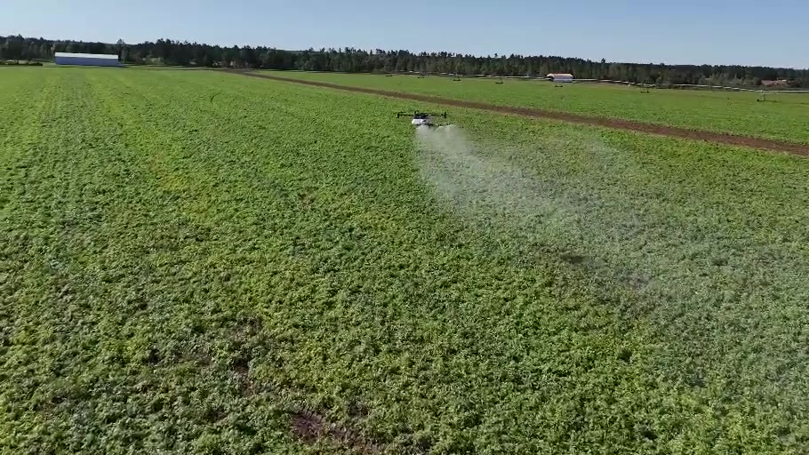 Harvest Drone’s Revolution R-40 applying product over a green crop field
